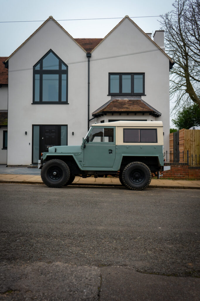 Classic Land Rover Lightweight captured outside a modern detached house in Northamptonshire.