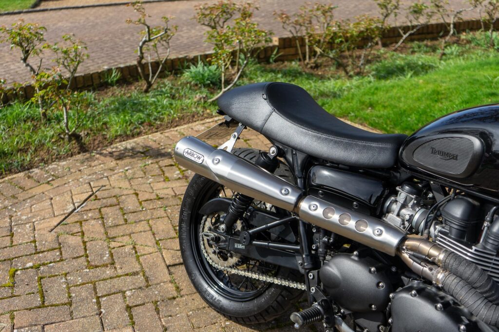Rear profile of a Triumph Bonneville T100 custom with arrow exhaust fitted.