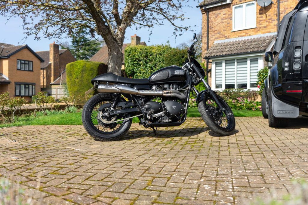 A Triumph Bonneville T100 Custom for sale in Northampton. This bike is captured on the driveway of the owner's house and aims to demonstrate the bike is from a good reliable home.